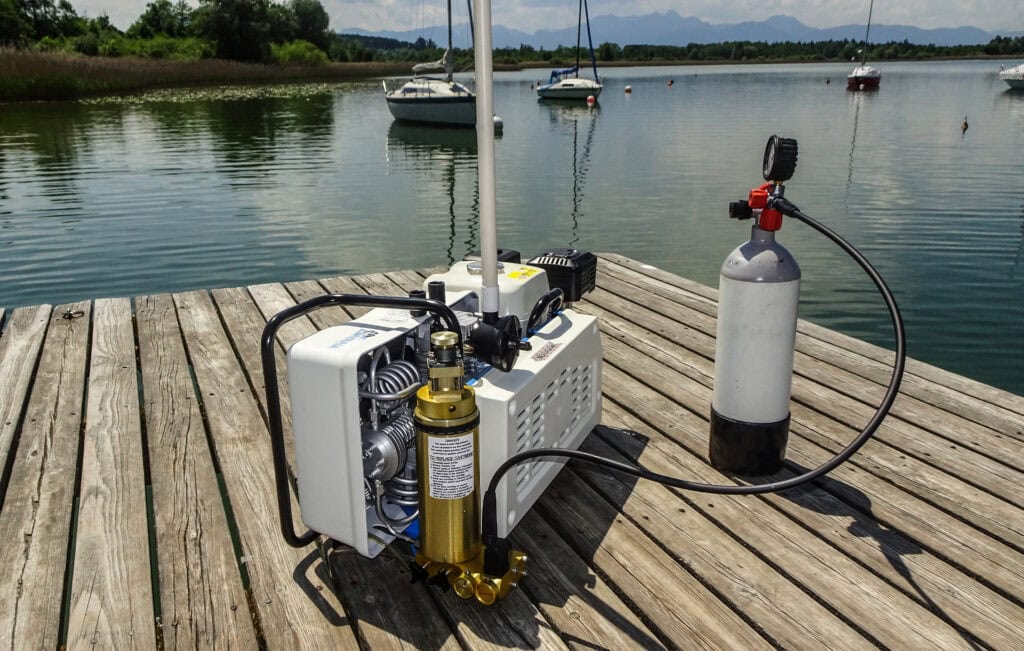Mobiler Atemluftkompressor füllt eine Tauchflasche auf einem Bootssteg
